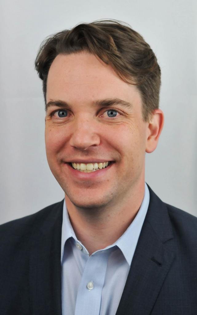 portrait of smiling young lawyer wearing dark suit and light blue shirt